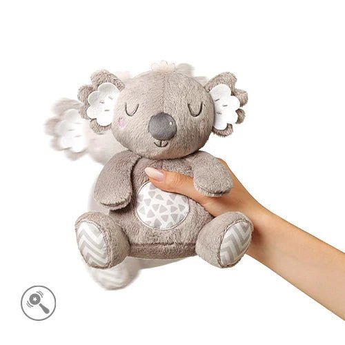 Light gray koala plush toy held by a hand, with embroidered eyes and patterned belly