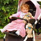 Plush dog toy with blue bandana and ribbon tag in stroller
