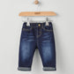 Dark blue denim jeans with cuffed hems, belt loops, and contrast stitching