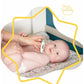 Green digital thermometer held by a hand next to a baby