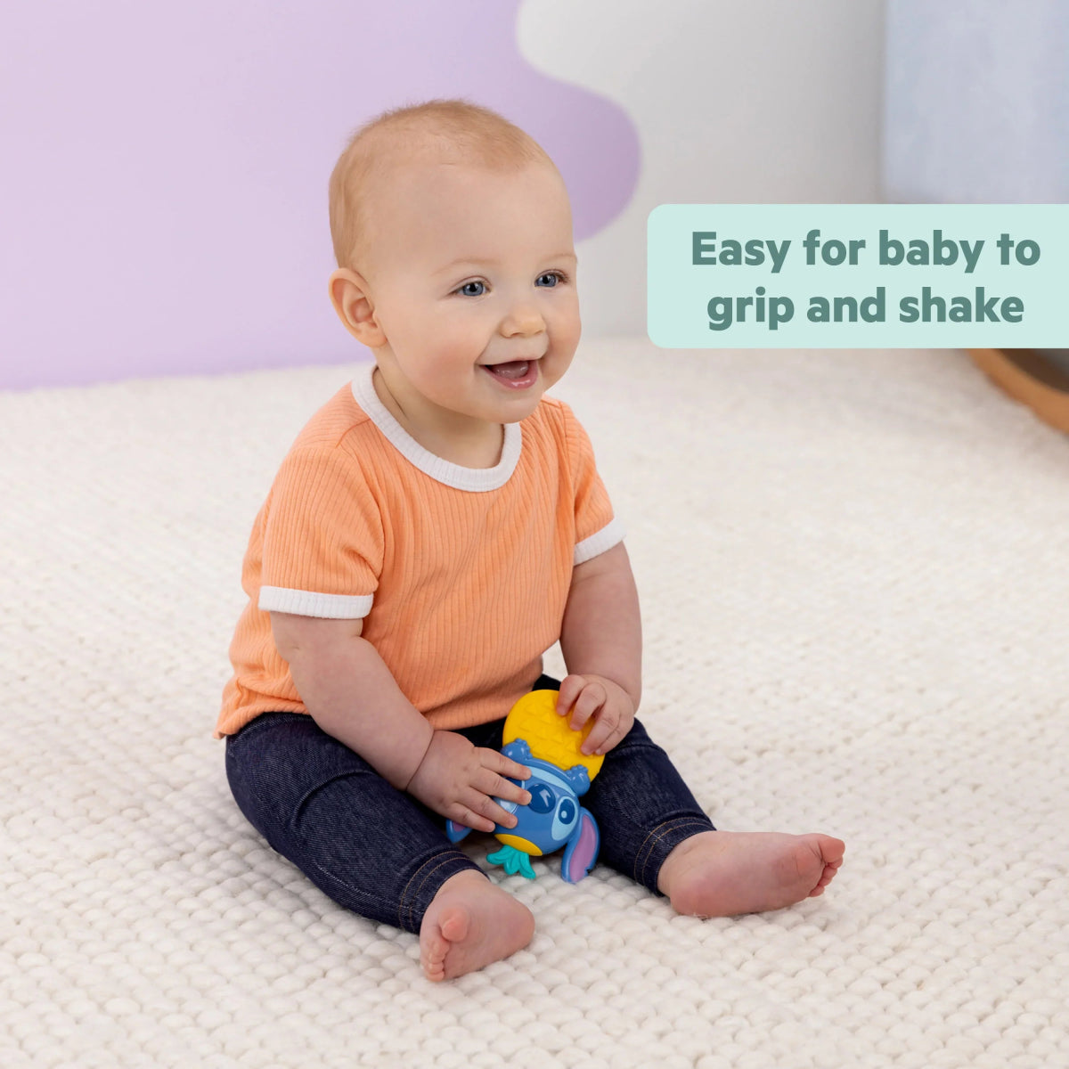 Stitch teether rattle gripped by a baby on a soft play mat