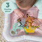 Inflatable water play mat with princess-themed floating pieces, close-up on hands