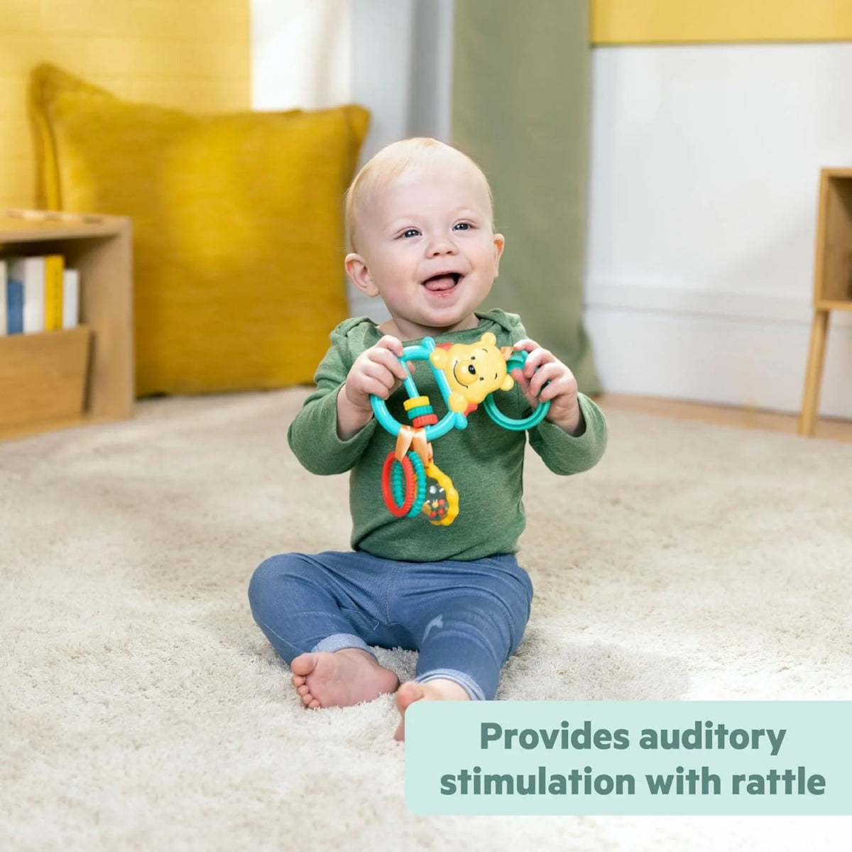 Winnie the Pooh stroller activity toy with multi-color rings and teal handle held by infant