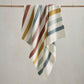 Knitted striped blanket, cream with blue, mustard, green, and red stripes