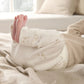 Cream duck-print leggings over a long-sleeve bodysuit, baby feet visible