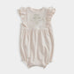 Shortie romper with ruffled shoulder sleeves and embroidered chest detail, pale pink