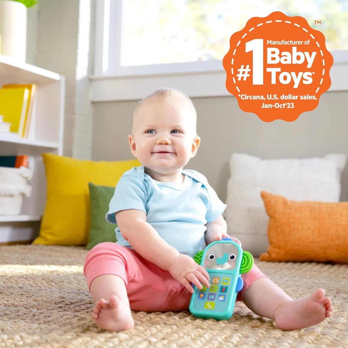 Small teal elephant baby phone toy with colorful buttons held on a living-room carpet