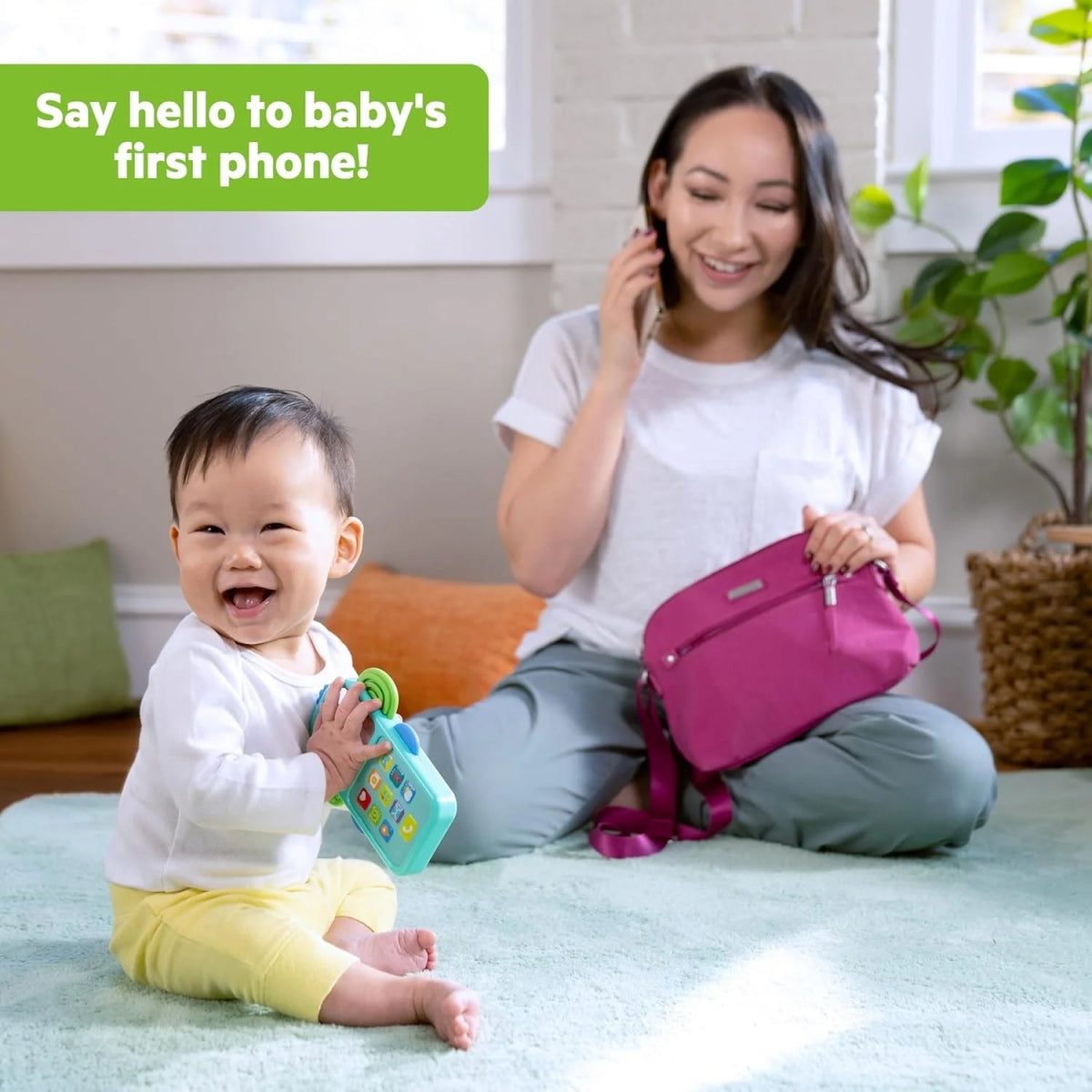 Teal elephant baby phone toy with colorful buttons in a child’s hand