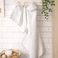 Baby towelling set of 3, white hooded towels hanging on wall