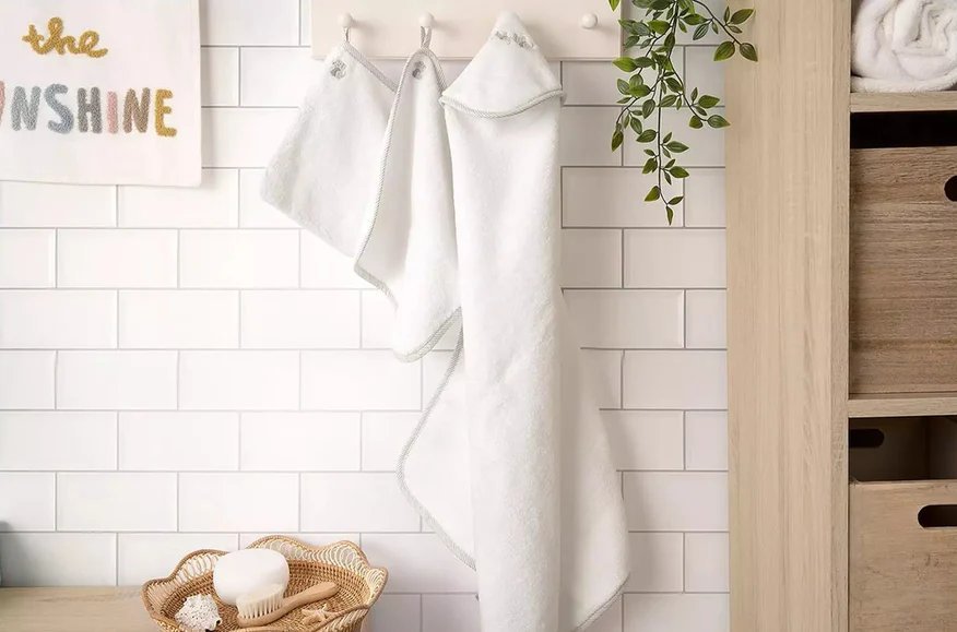 Baby towelling set of 3, white hooded towels hanging on wall
