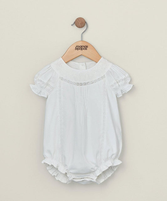 White embroidered baby romper with ruffled sleeves and eyelet trim