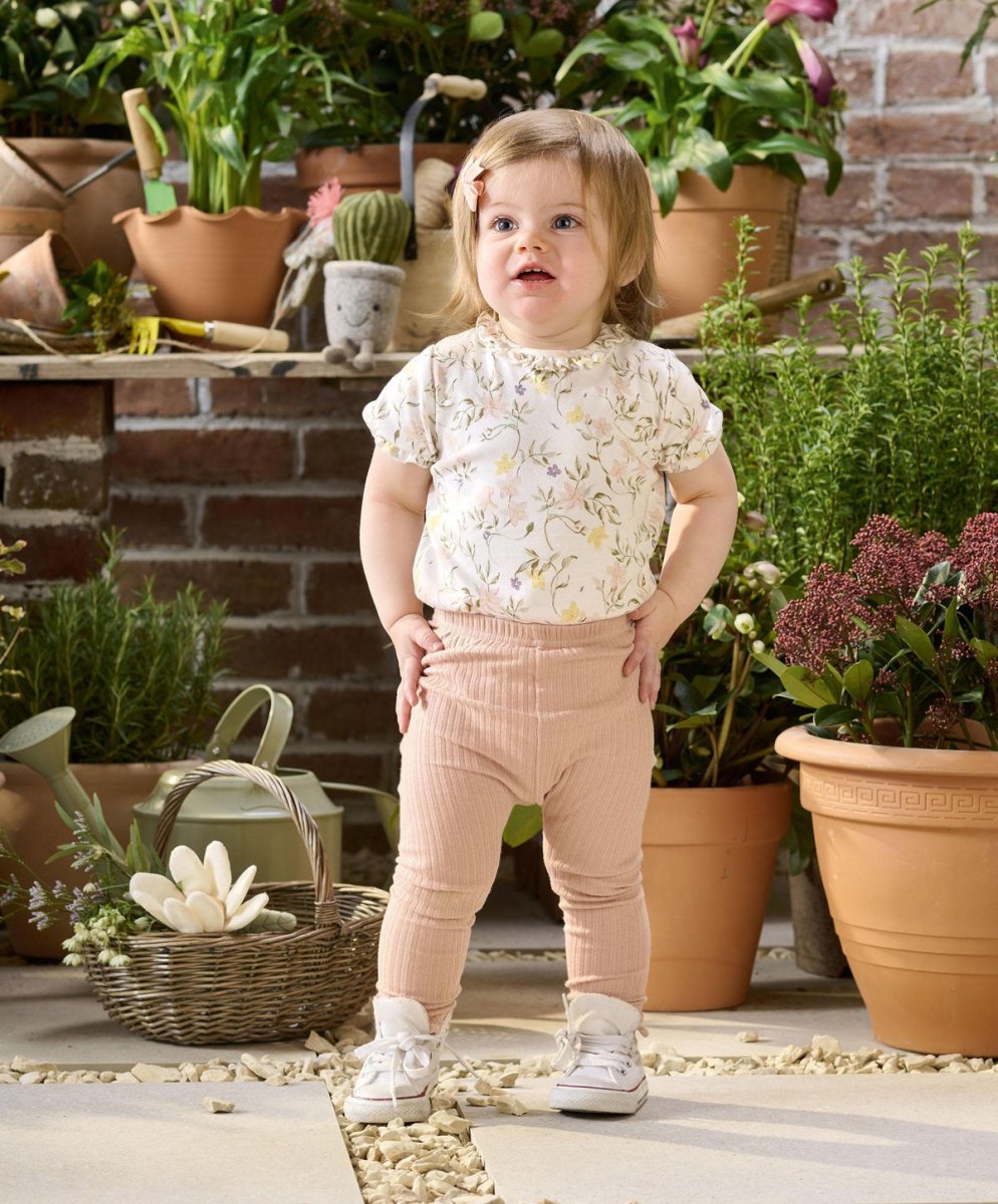 Floral baby bodysuit with short sleeves and round neckline, paired with pink pants