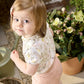 Floral baby bodysuit with short sleeves and round neckline worn by child