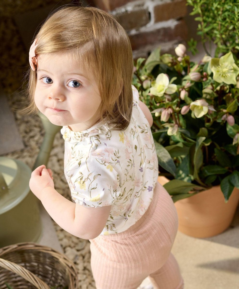 Floral baby bodysuit with short sleeves and round neckline worn by child