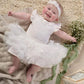 White bodysuit with ruffled collar, layered tulle skirt, and matching headband