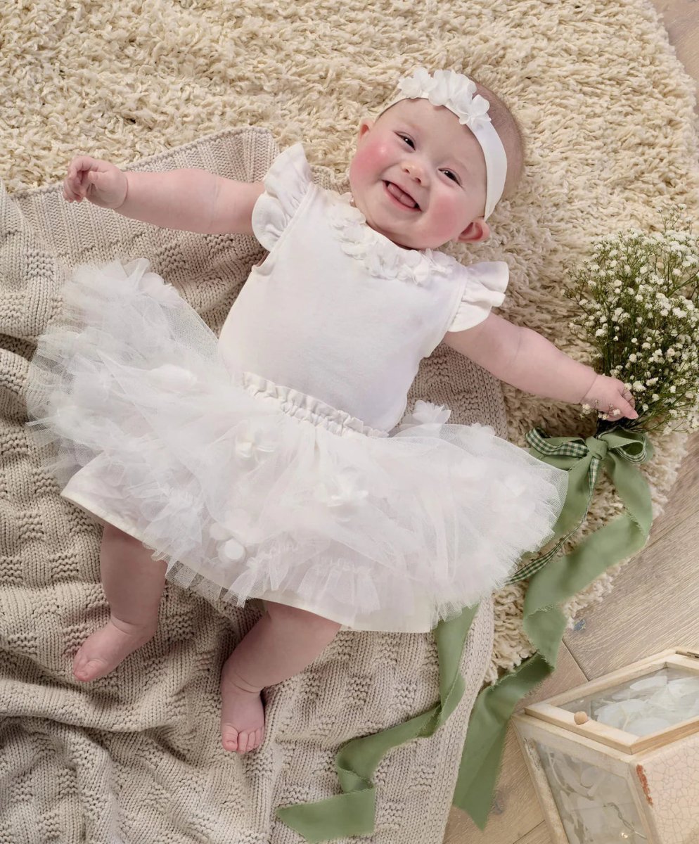 White bodysuit with ruffled collar, layered tulle skirt, and matching headband