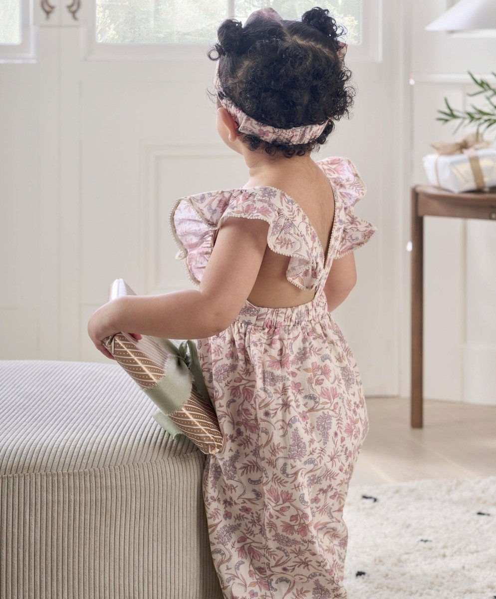 Back-view floral baby dungarees with straps and gathered ruffle, light pink print