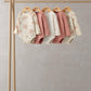 Long-sleeve floral bodysuits, five-pack on hangers in cream and pink shades