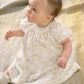 Baby in floral print dress with gathered yoke and short puff sleeves