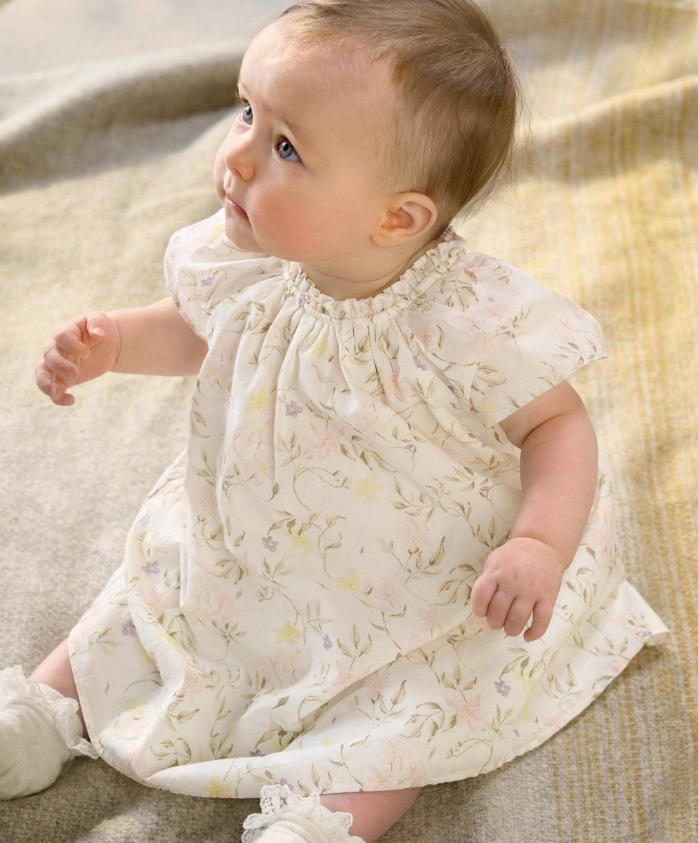 Baby in floral print dress with gathered yoke and short puff sleeves