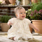 Baby wearing floral print dress with ruffled gathered bodice and short sleeves