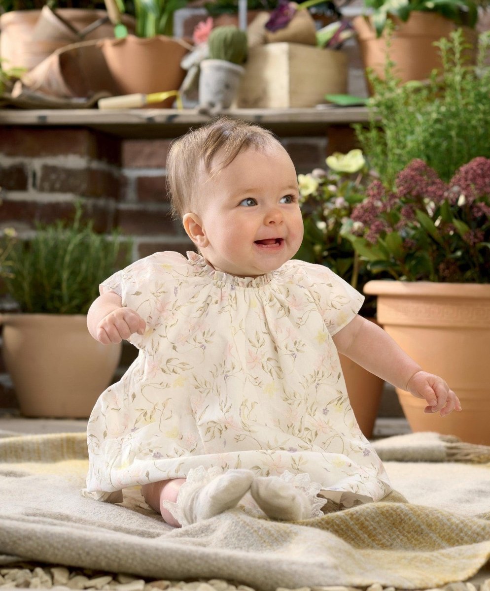 Baby wearing floral print dress with ruffled gathered bodice and short sleeves