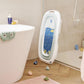 Foldable baby bathtub folded upright with a blue inner panel, white outer shell