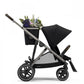 Black stroller with canopy, side basket tray, and large spoked wheels
