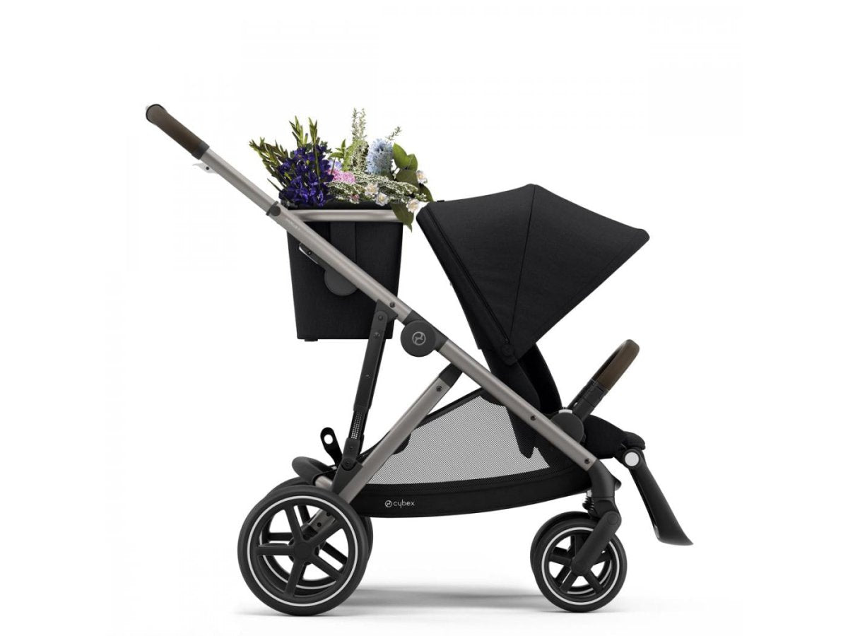 Black stroller with canopy, side basket tray, and large spoked wheels