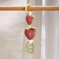 Strawberry activity toy with wooden ring, two strawberry links, and leaf detail