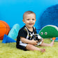 Black and white soccer rattle ball with colorful rattle window held in seated hands