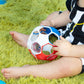 Red, white, and blue rattle soccer ball grasped by a child’s hands