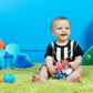 Red, white, and blue rattle soccer ball held by a sitting baby