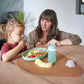Silicone feeding bowl set with mint bottle and feeding spoons on table