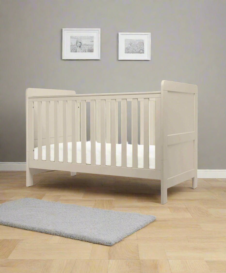Cotbed in light grey with slatted guardrail and rectangular panel headboard and footboard