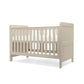 Cotbed in light grey with corner posts and vertical slatted side guard rail