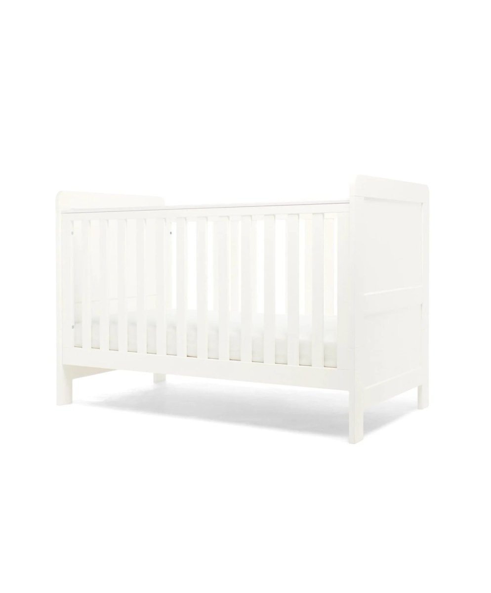 White cotbed with vertical slat sides and paneled headboard, toddler bed ready design