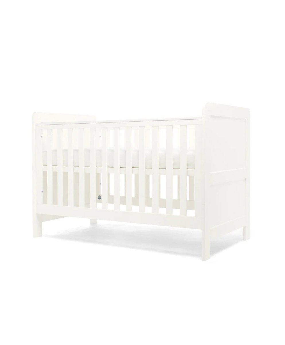 White cotbed with paneled end board and tall slat headboard, front three-quarter view