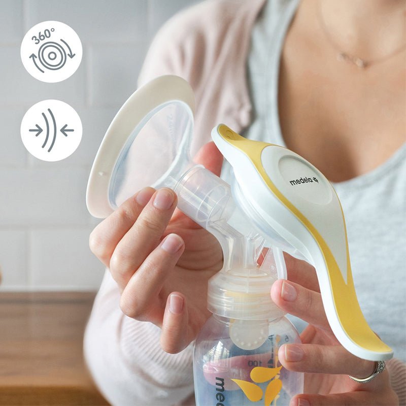 Manual breast pump held with white flange and clear bottle by hands
