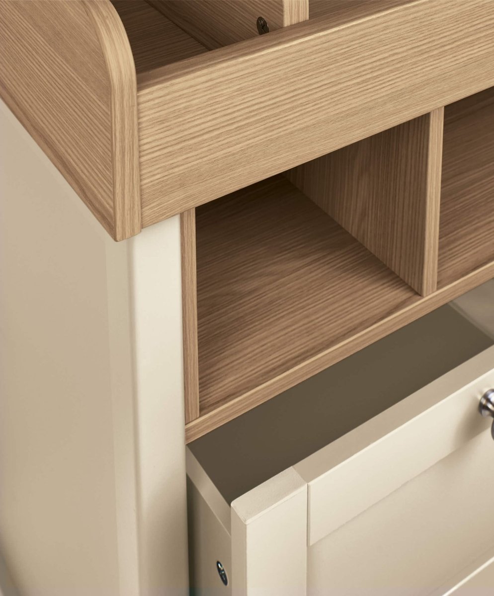 Baby dresser changer close-up of wood changing rail and open shelf below
