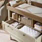 Baby changing dresser with open top shelf and lower drawers, light cream frame
