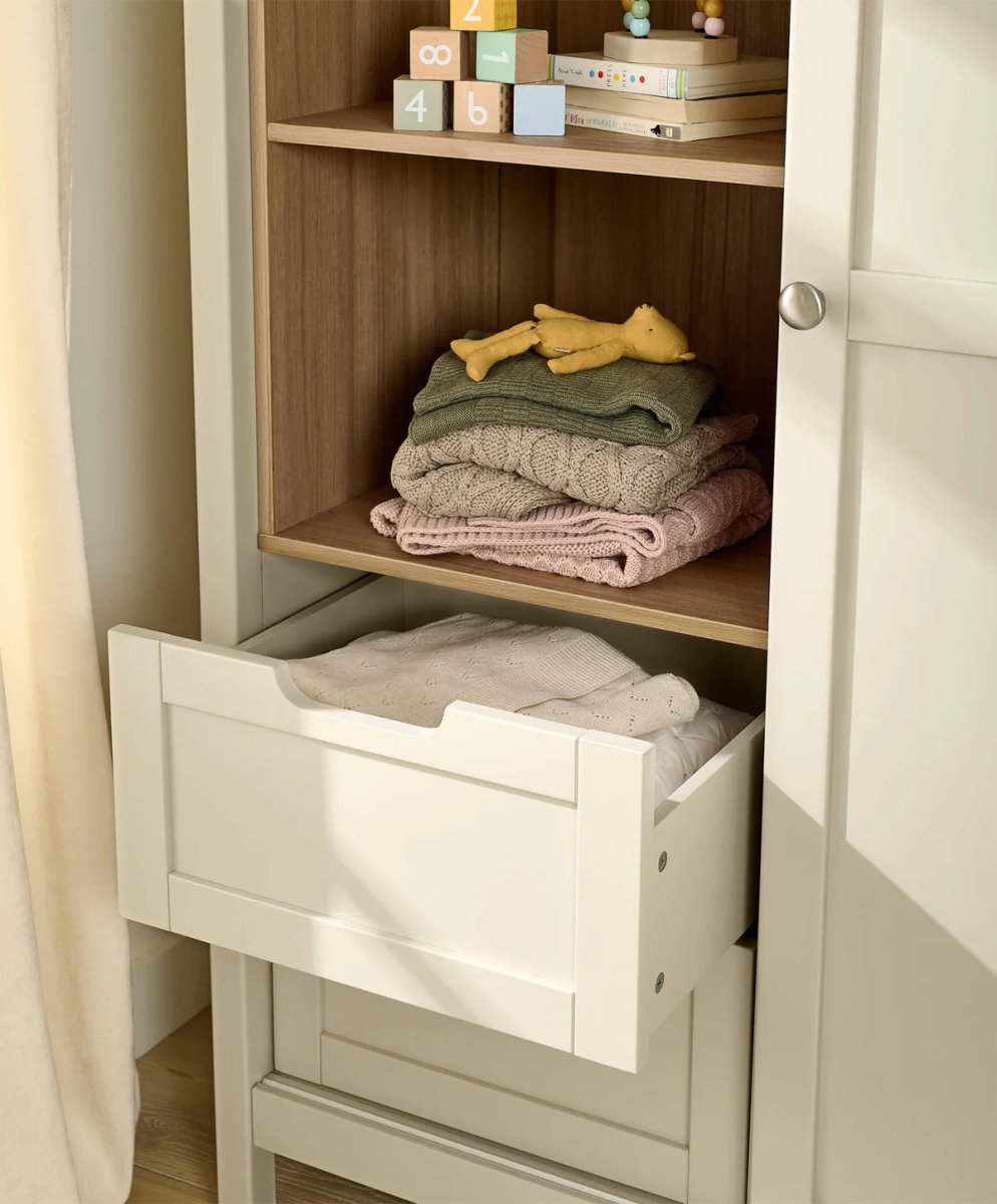 Wardrobe cabinet interior with stacked folded cashmere sweaters on shelves and drawer bin