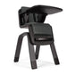 High chair three-quarter view with dark seat cover and curved back shell