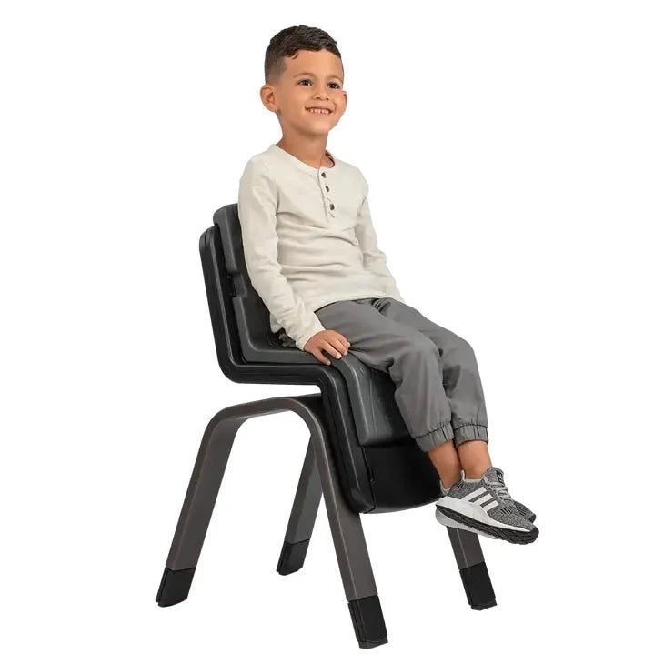 Toddler sitting in a dark gray high chair with tray and side armrests