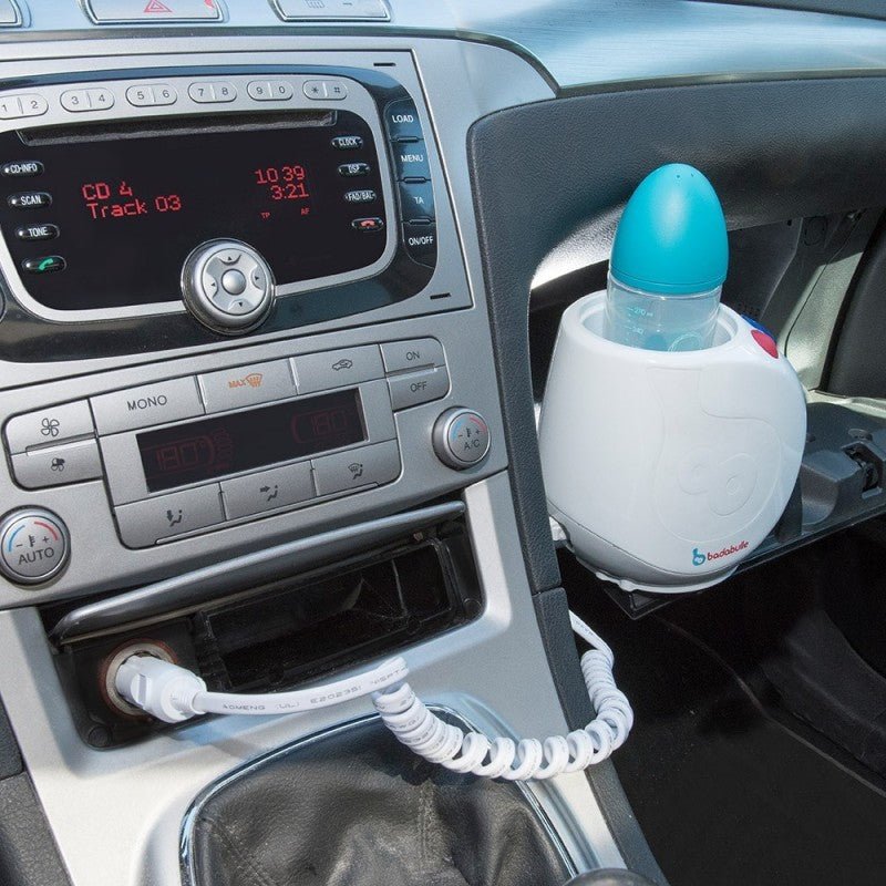 White and blue bottle warmer in a car cup holder with bottle inside