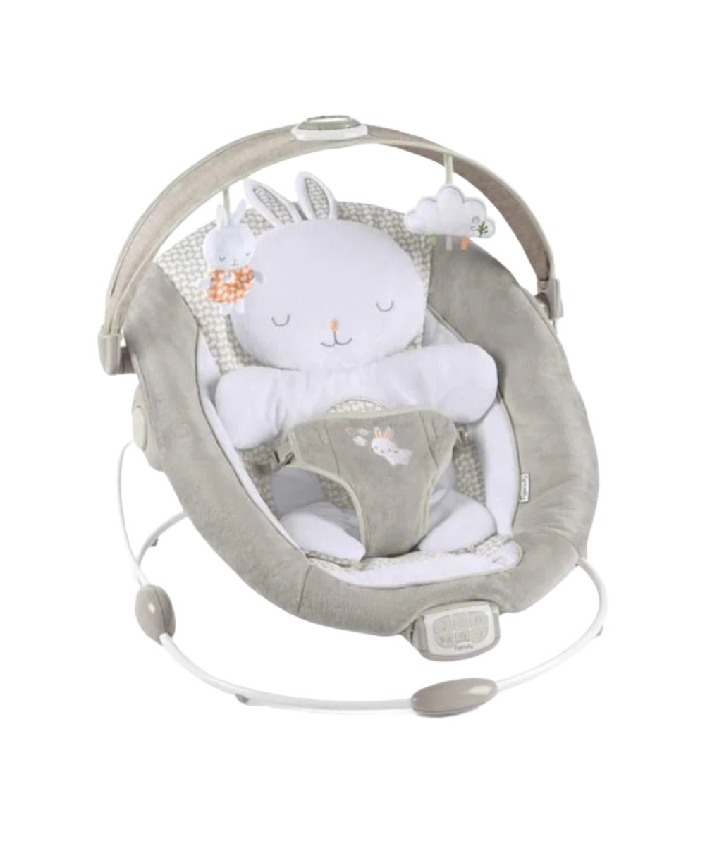 Infant bouncer with grey seat, white bunny head cushion, and toy arch