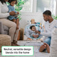 Baby bouncer with gray seat, teal accents, and toy bar in home