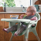 Eucalyptus green baby high chair with front tray, baby sitting in it