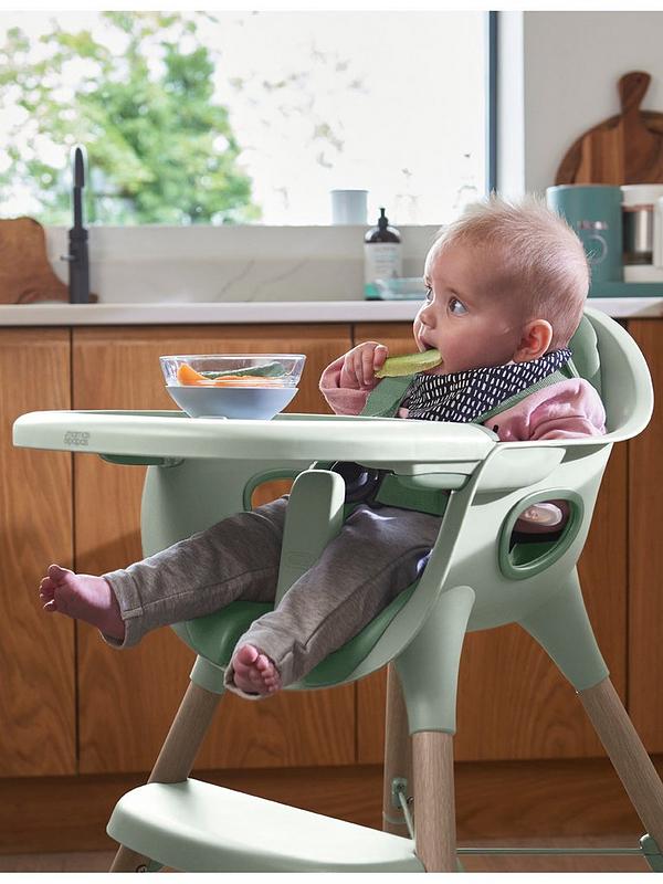 Eucalyptus green baby high chair with front tray, baby sitting in it