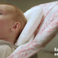 Baby bouncer seat with white cover and red line pattern, plush headrest and straps